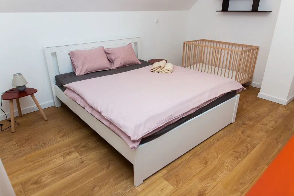 Podkrovná spálňa s drevenou posteľou